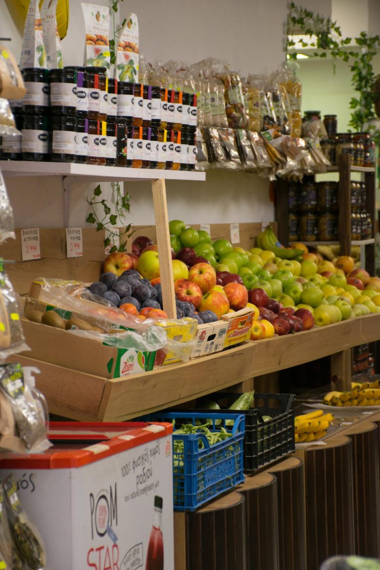 Vibrant fruit display in a Greek market, showcasing apples, bananas, and more.